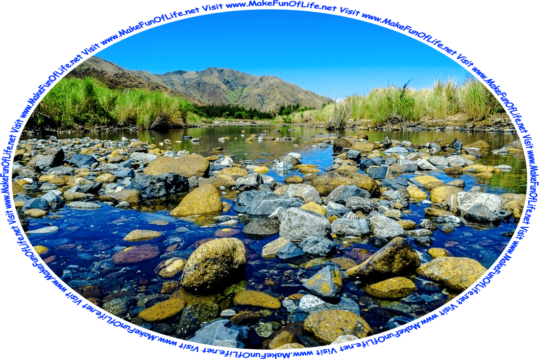 Picture of clear shallow water with large numbers of river stones partially submerged it, tall green grass along its banks, hills in the distance, a clear blue sky above, and the words, ‘Visit www.MakeFunOfLife.net.’